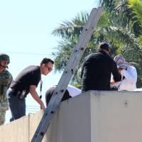 A soldier stands guard as forensic technicians work at a crime scene where the body of a man, who witnesses said was tossed from a plane, landed on a hospital roof in Culiacan, in Mexico\'s northern Sinaloa state Wednesday. | REUTERS