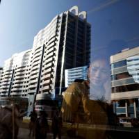 North Koreans riding in a bus pass newly constructed buildings in central Pyongyang on Wednesday. | REUTERS