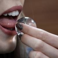 A woman consumes an Ooho plastic-less water container in London on Wednesday. | REUTERS