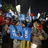 South Koreans march against deploying the THAAD missile defense system on Saturday near the U.S. Embassy in Seoul. | AP