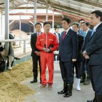 Prime Minister Shinzo Abe inspects a livestock farm in the town of Naraha, Fukushima Prefecture, near the heavily damaged Fukushima No. 1 nuclear power plant on Saturday. Abe visits Fukushima with Imamura, repeats pledge to back 3/11 reconstruction
