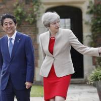 British Prime Minister Theresa May shows her Japanese counterpart, Shinzo Abe, around the garden at Chequers on Friday. 	          pool / via AP | AP