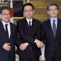 Joseph Yun (from left), U.S. special representative for North Korea policy, Kenji Kanasugi, director-general of the Foreign Ministry\'s Asian and Oceanian Affairs Bureau, and Kim Hong-kyun, special representative for Korean Peninsula peace and security affairs at the South Korean Foreign Ministry, join hands before their meeting about North Korean issues at the Iikura Guesthouse in Tokyo on Tuesday. | AP