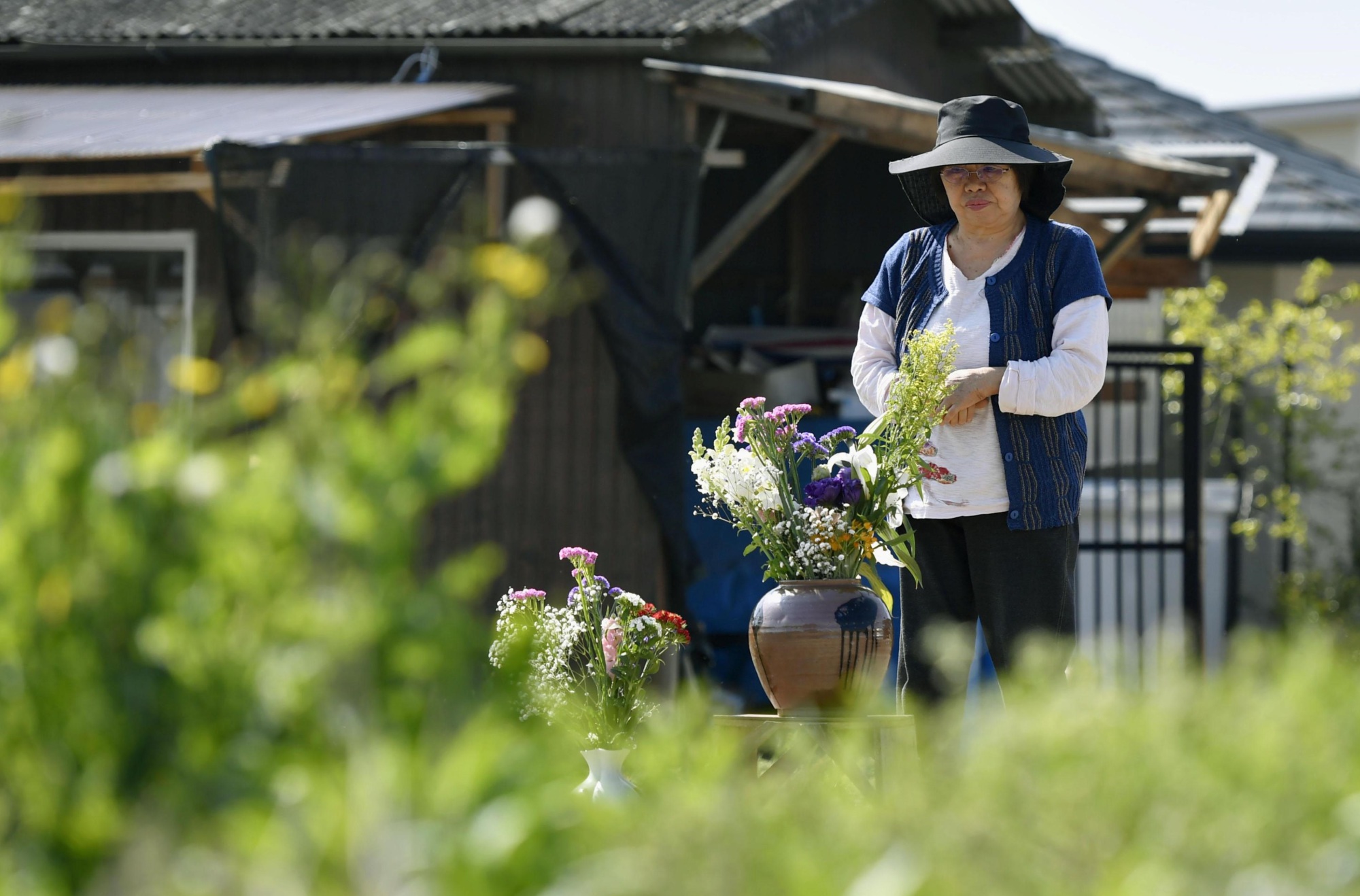 A woman prays Friday in the town of Mashiki, Kumamoto Prefecture, a year after  strong earthquakes hit the region and claimed her sister-in-law. | KYODO
