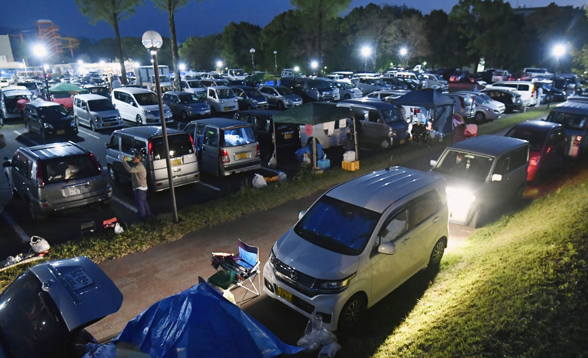 A parking lot in the town of Mashiki, Kumamoto Prefecture, is packed with vehicles after strong earthquakes hit the region in April 2016. | KYODO