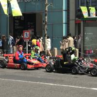 Tourists are seen driving rented MariCar go-karts in Shibuya Ward, Tokyo, on April 2. | MAGDALENA OSUMI