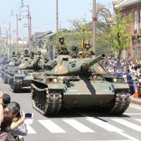 The 14th brigade of the Ground Self-Defense Force runs its tanks during a parade in the city of Zentsuji in Kagawa Prefecture on Sunday. KYODO | REUTERS