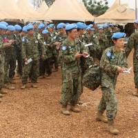 Japanese soldiers from the United Nations Mission in South Sudan (UNMISS) are processed by an immigration offiecer as they withdraw from their mission in South Sudan\'s capital, Juba, on Monday. | REUTERS