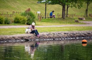 A woman plays with her dog on the banks of a river in Tokyo’s Koto Ward.