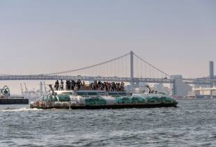 Tourists enjoy the view from atop the Hotaluna water bus in Tokyo.