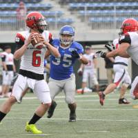 IBM linebacker KazumasaTakahashi (right) puts pressure on Bulls quarterback Keita Fujiwara in the third quarter. | HIROSHI IKEZAWA