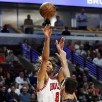 Bulls center Robin Lopez shoots over the Hawks’ Kris Humphries during the first half of their game on Saturday in Chicago. Bulls stay alive in playoff hunt with crucial win over Hawks