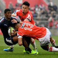 The Sunwolves\' Timothy Lafaele (13) and Yu Tamura tackle Warrick Gelant of the Bulls during their Super Rugby match at Prince Chichibu Memorial Ground on Saturday. | AFP-JIJI