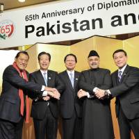 Pakistan\'s Ambassador Farukh Amil (second from right) joins hands with (from left) House of Councillors member Antonio Inoki,  Komeito President Natsuo Yamaguchi, Japan-Pakistan Parliamentarians\' Friendship League President Seishiro Eto  and Parliamentary Vice Minister for Foreign Affairs Motome Takizawa during a reception to celebrate Pakistan national day and the 65th anniversary of diplomatic relations with Japan at the Hotel Okura, Tokyo, on March 23. | YOSHIAKI MIURA