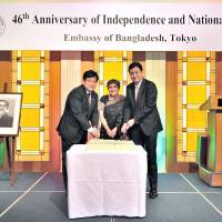 Bangladesh\'s Ambassador Rabab Fatima (center), Secretary-General of Japan-Bangladesh Parliamentarians\' League Ichiro Tsukada (left) and State Minister for Foreign Affairs Nobuo Kishi cut a cake during a reception to celebrate the 46th anniversary of independence and the national day of the People\'s Republic of Bangladesh at the Hotel Okura, Tokyo, on March 28. | YOSHIAKI MIURA