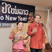 Lao Ambassador Viroth Sundara (right) and his wife Simuang propose a toast at a celebration of the Lao New Year, or Buddhist year 2560. | YOSHIAKI MIURA