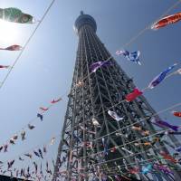 With Tokyo Skytree towering over them, carp streamers fly in the wind at the Skytree Town commercial complex in Sumida Ward on Friday. The streamers were strung up ahead of Children\'s Day on May 5 to reflect parents\' wishes that their children grow up to be as strong as the fish. The streamers &#8212; all 634 of them &#8212; will be on display through May 7.  | SATOKO KAWASAKI