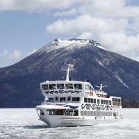 The sightseeing boat Mashu Maru plies Lake Akan in Hokkaido on Monday to break up the ice ahead of the start of tourism operations in May. Tourists will be able to ride the Mashu Maru to experience its springtime ice-breaking duties for about a week starting Friday. | KYODO