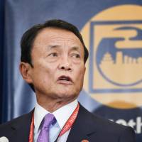 Finance Minister Taro Aso speaks to reporters Saturday evening in Yokohama after meeting with his Chinese counterpart in the first bilateral meeting of the countries\' finance chiefs in nearly two years. | KYODO