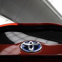 A Toyota badge is seen on a Prius plug-in hybrid at the automaker\'s Tokyo head office. Toyota Motor Corp. is said to be considering issuing up to &#165;100 billion in bonds to invest in developing next-generation car technologies. | BLOOMBERG