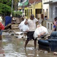 Residents of the city of Barreiros try to save their belongings from their homes affected by floods from heavy rain in Pernambuco state, northeastern Brazil Tuesday. Brazil floods force 50,000 to flee, kill at least six: authorities