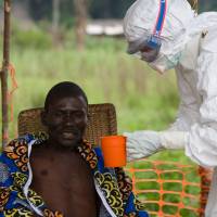 This 2007 file handout released by the World Health Organization shows international nongovernmental organization Doctors Without Borders (MSF) doctor Hilde Declerck taking care of a 43-year-old patient, suffering from Ebola haemorrhagic fever (EHF) at an MSF isolation ward in Kampungu. The Democratic Republic of the Congo is facing a new epidemic of Ebola haemorrhagic fever, which occurred in a landlocked northeastern region, where the disease has claimed three deaths since April 22, according to the WHO. | CHRISTOPHER BLACK / WORLD HEALTH ORGANIZATION / VIA AFP-JIJI