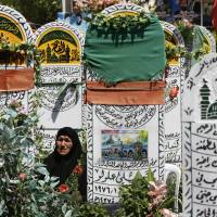 A prays at the grave of her son, who died fighting Syrian insurgents, in the Sayyidah Zaynab suburb of Damascus on Friday. Near a shrine, the new cemetery holds the remains of hundreds of Shiite fighters, testimony to the high cost of Iran\'s military intervention in Syria. | AP