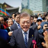 Presidential candidate Moon Jae-in is surrounded by supporters after attending a ceremony celebrating the birthday of Buddha at Jogye temple in Seoul on Wednesday. In the South, voters seeking 'Korea first' leader may head to polls in near-record numbers