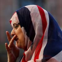 A woman wears a union jack hijab in St. Ann\'s Square, in central Manchester, Britain, on Friday. | REUTERS