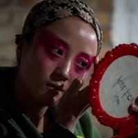 A Jin opera performer prepares backstage at an outdoor theater in a village in Yu County, in China’s Hebei province, on March 30. Defending a dying art, opera troupe tours rural China