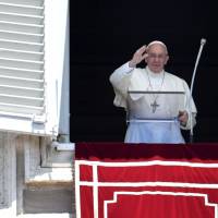 Pope Francis waves to the crowd from the window of the apostolic palace overlooking St. Peter\'s Square during the Regina Coeli prayer at the Vatican on Sunday. | AFP-JIJI
