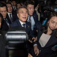 South Korean presidential candidate Moon Jae-in arrives at his home after visiting his party heaquarters as votes are counted in Seoul on May 9. South Korean President-elect Moon's main policy pledges