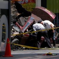 Police investigate the vehicle that drove onto sidewalk and struck pedestrians in Times Square in New York Thursday. U.S. Navy veteran kills one, injures 22 in Times Square vehicle incident