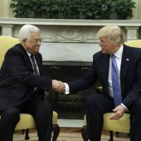 President Donald Trump (right) welcomes Palestinian leader Mahmoud Abbas during their meeting in the Oval Office of the White House Wednesday in Washington. Without specifics, Trump assures Abbas on Middle East peace: 'We will get it done'