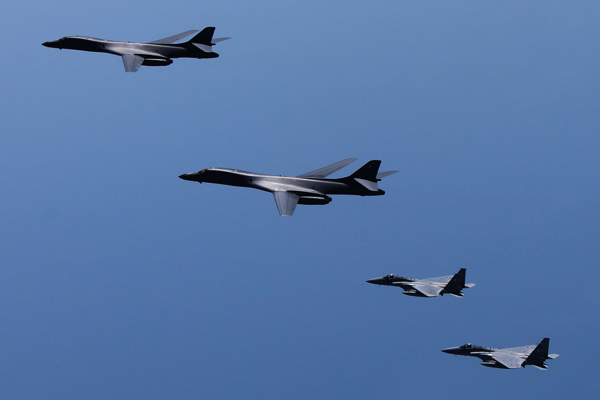 A pair of U.S. B-1B strategic bombers conduct joint drills with Air Self-Defense Force F-15s in airspace over the Kyushu region Monday. | JAPANESE DEFENSE MINISTRY