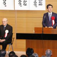 Prime Minister Shinzo Abe speaks at a gathering in Tokyo Monday of a cross-party league of lawmakers who favor amending the Constitution, alongside former Prime Minister Yasuhiro Nakasone. | KYODO