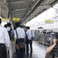 Reporters gather Friday at a platform in JR Okayama Station, where an elderly man was arrested for allegedly starting a fire inside a shinkansen. | KYODO