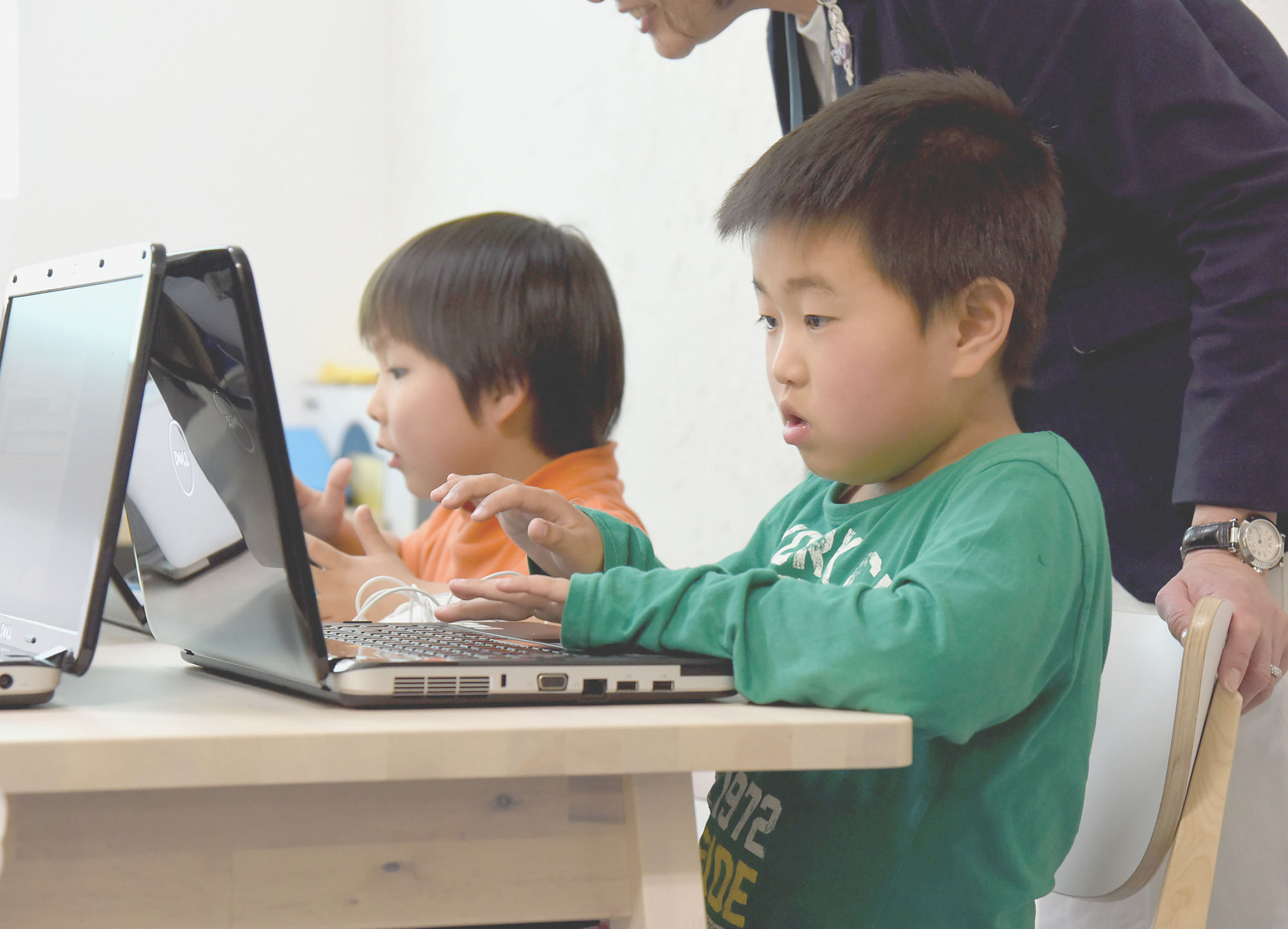Eita Ide (right) studies computer programming at Kid’s Tech, a newly opened cram school catering to the needs of children with developmental disabilities in Tokyo’s Ota Ward in mid-April. | SATOKO KAWASAKI