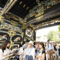 Tourists walk through the Karamon gate of Nishi Honganji Temple in Kyoto on Sunday. The gate, a national treasure, was opened for the first time in 34 years. | KYODO