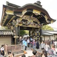 Tourists walk through the Karamon gate of the Nishi Honganji Temple in Kyoto on Sunday. | KYODO