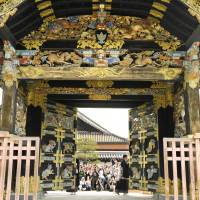 Tourists see the Karamon gate of the Nishi Honganji Temple being opened in Kyoto on Sunday. | KYODO