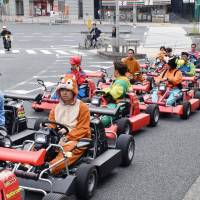 A go-kart tour winds its way through a public road in the middle of Tokyo last week. | KYODO