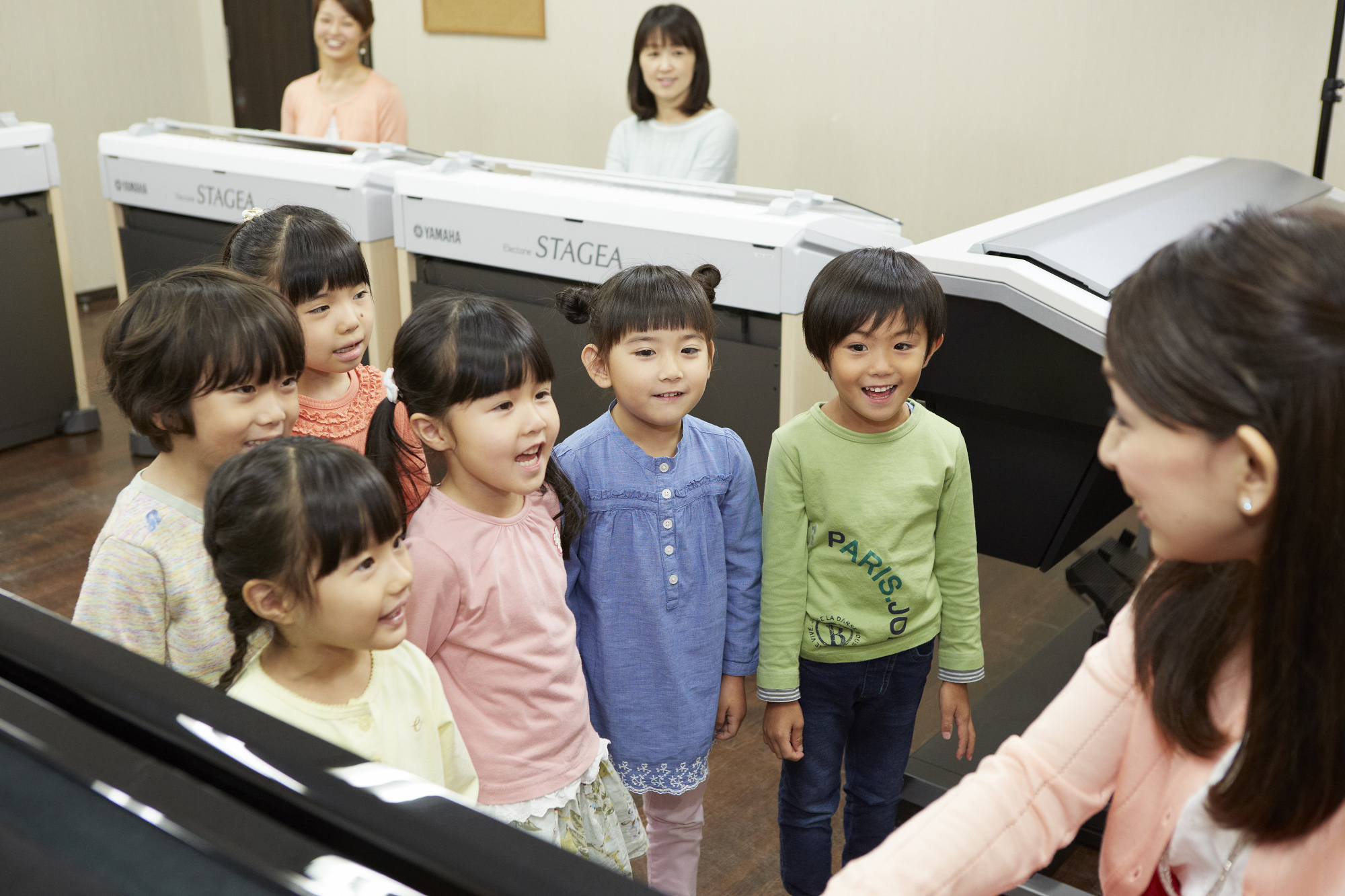 Children listen to a teacher's piano performance during a music lesson at a Yamaha Music Foundation school. Yamaha has 3,300 outlets across Japan. | YAMAHA MUSIC FOUNDATION