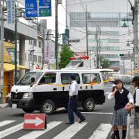 A police van blocks a street in the city of Hanno, Saitama Prefecture, after grenade-like objects were found near Higashi-Hanno Station on Thursday. Grenade replicas prompt evacuation of Saitama train station