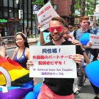 Marchers carry the rainbow flag during the annual Tokyo Rainbow Pride event held in the Shibuya district of central Tokyo on Sunday. This year’s theme was “change,” a call to respect everyone as individuals, regardless of their sexuality. | YOSHIAKI MIURA