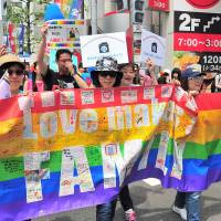 Marchers carry the rainbow flag during the annual Tokyo Rainbow Pride event held in the Shibuya district of central Tokyo on Sunday. This year’s theme was “change,” a call to respect everyone as individuals, regardless of their sexuality. | YOSHIAKI MIURA