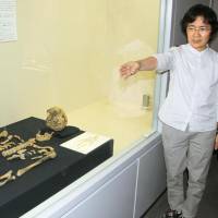 A human skeleton believed to be about 27,000 years old is displayed at a cultural facility in the town of Nishihara in Okinawa on Friday. | KYODO