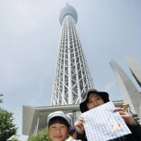 Visitors hold commemorative souvenirs at Tokyo Skytree on Monday as it marked its fifth anniversary. About 26 million people had visited the landmark as of March. | KYODO