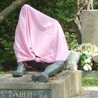 The damaged statue of Japanese engineer Yoichi Hatta, who made great contributions to the agricultural development in Tainan, southern Taiwan, during Japan\'s colonial rule, is seen covered with a tarp last month. | CENTRAL NEWS AGENCY / VIA KYODO
