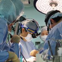 Doctors perform lung transplant surgery on a 1-year-old girl at Okayama University Hospital on Thursday. | OKAYAMA UNIVERSITY HOSPITAL / VIA KYODO